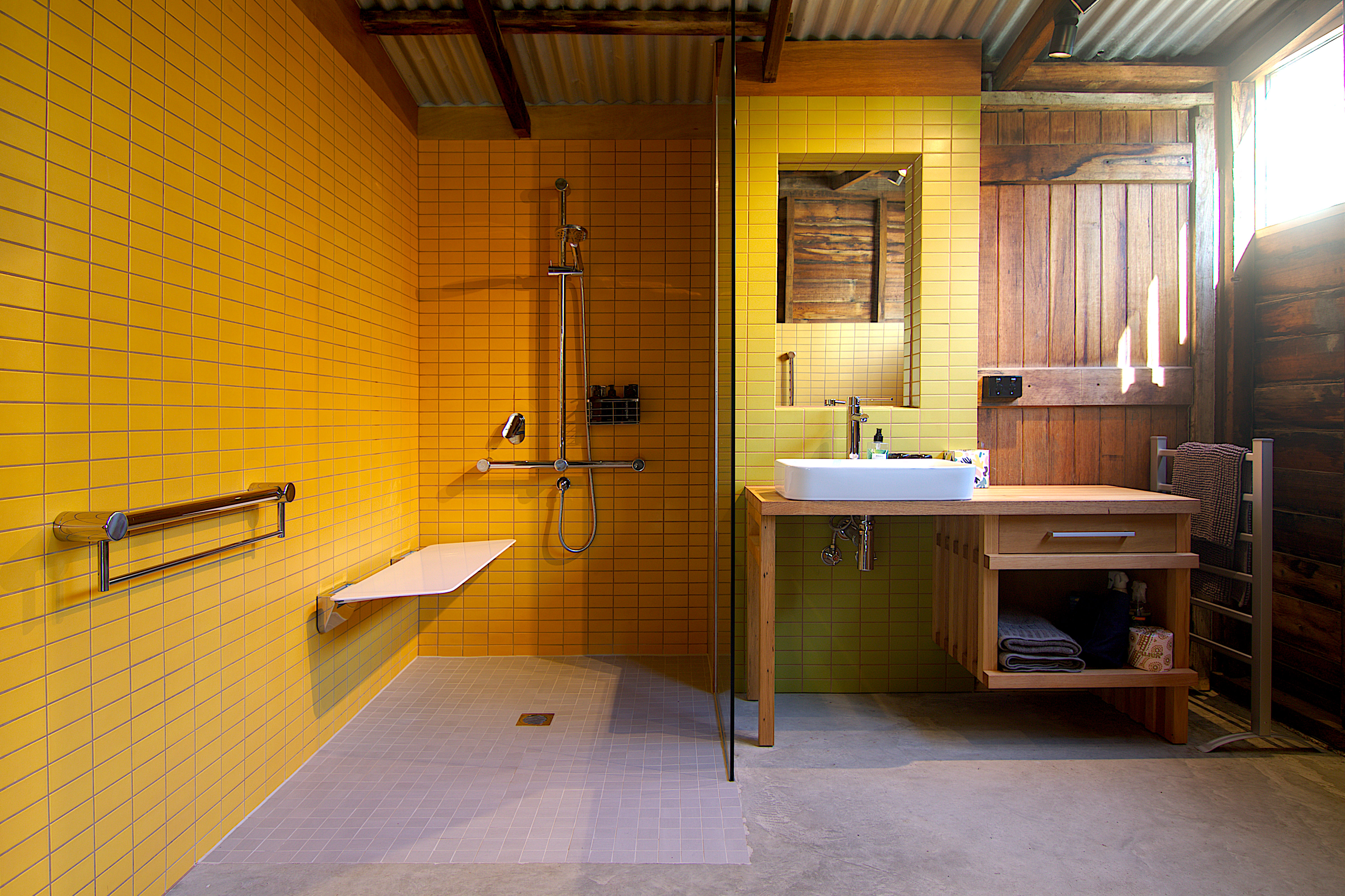 bathroom with folding white shower seat in down position