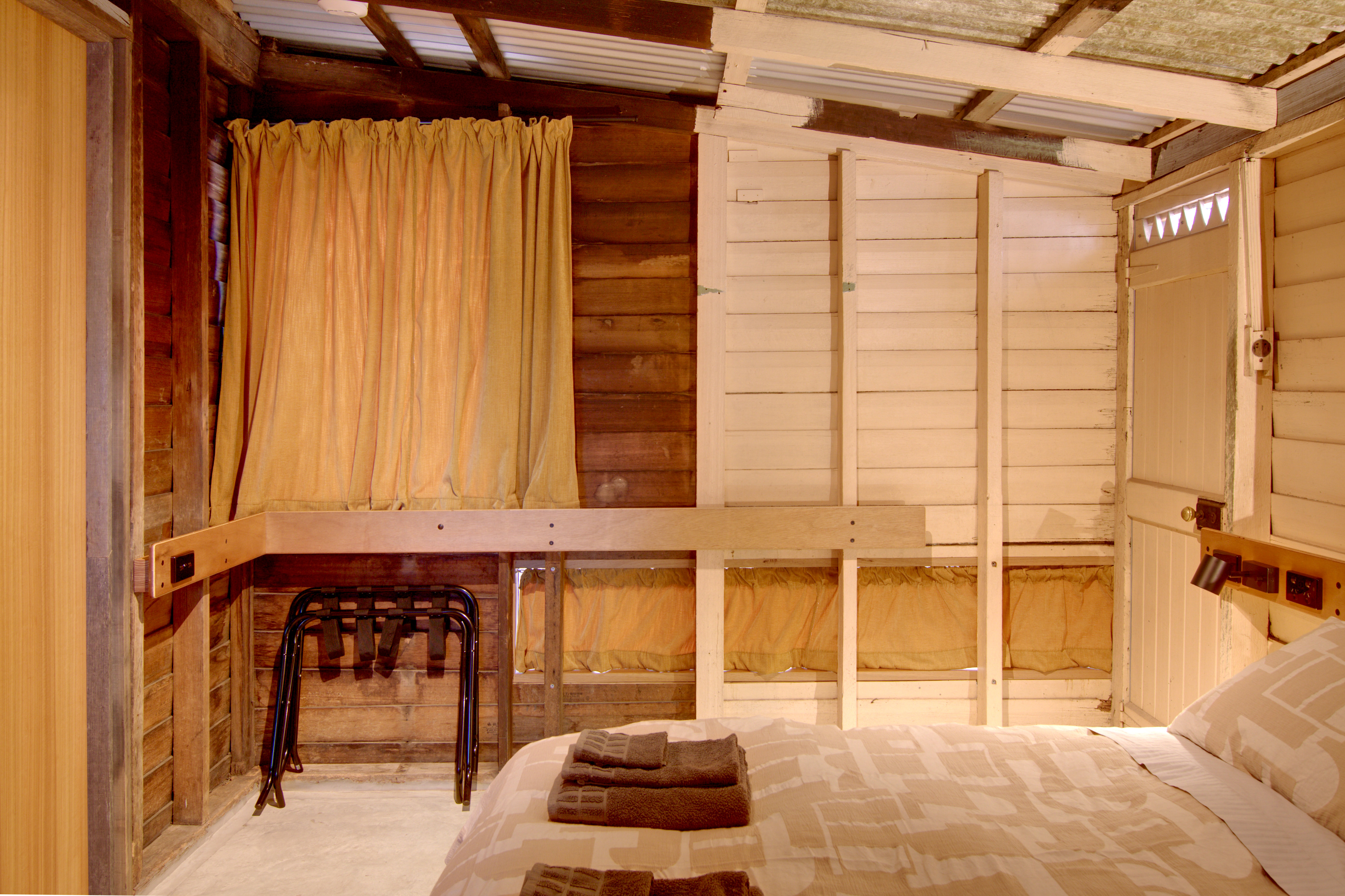bedroom-main-curtains-closed-luggage-rack-towels