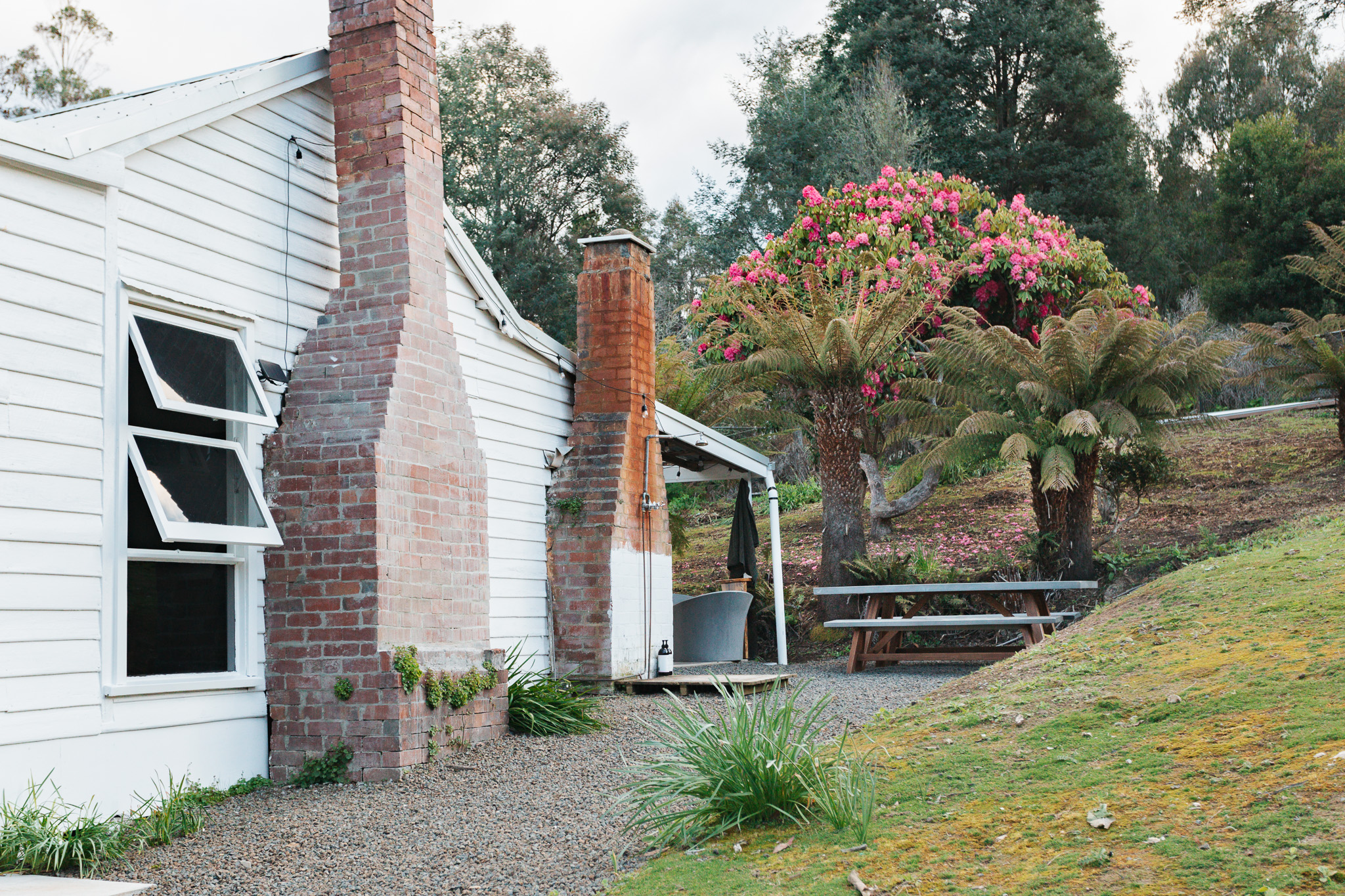 Property exterior with two original brick chimneys and an outdoor bath.