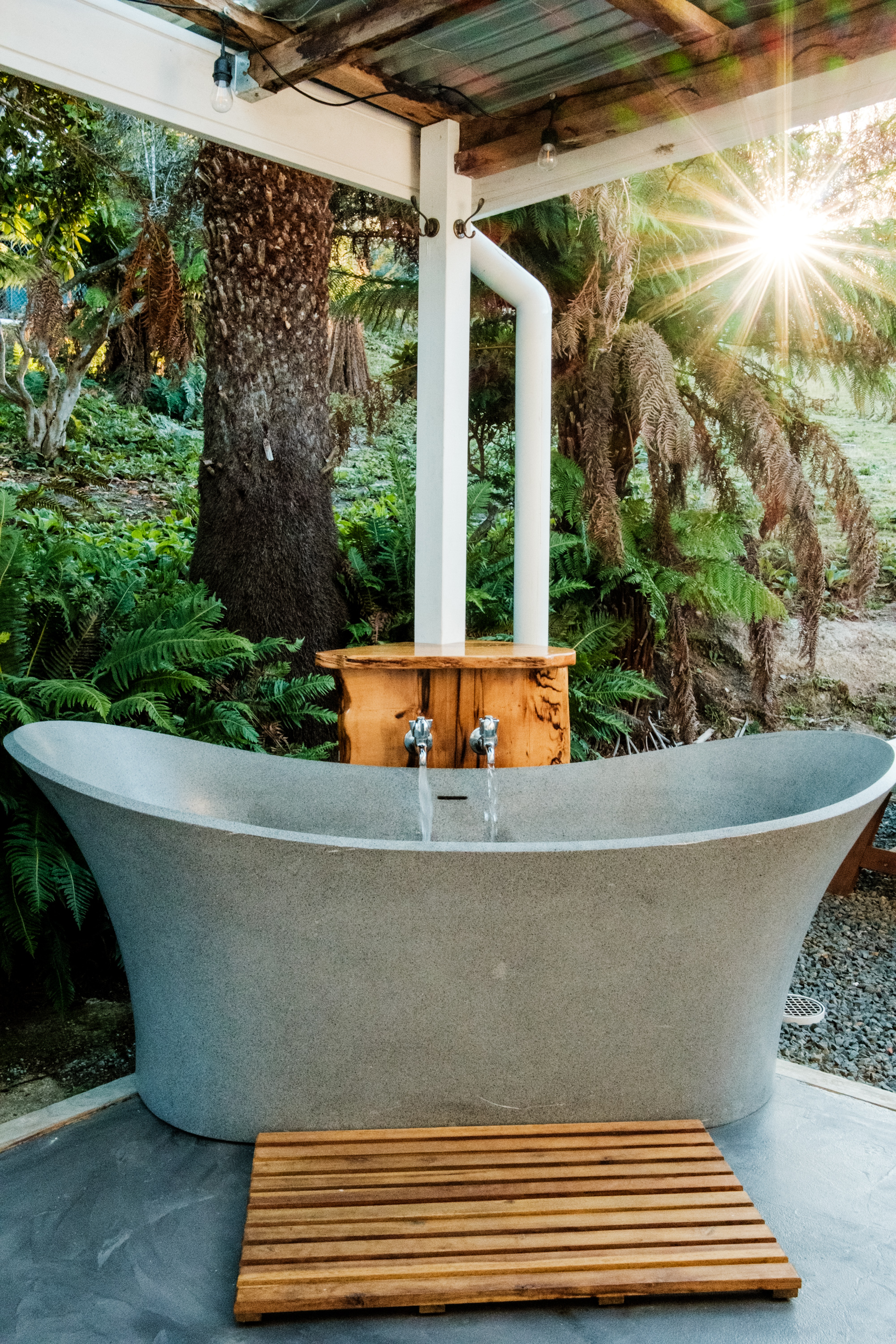 Outdoor bath with taps running.