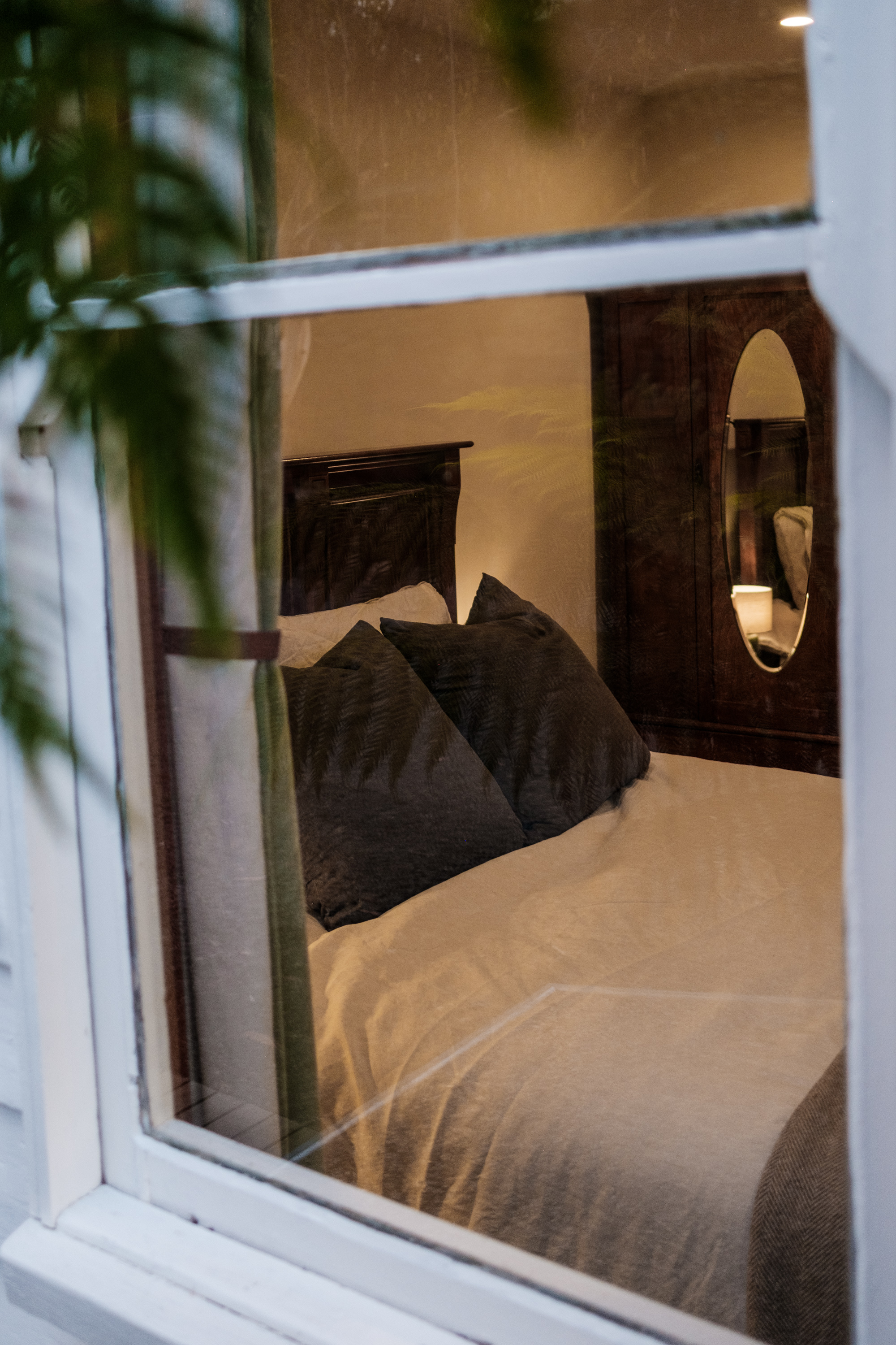 One of three bedrooms at nighttime from outside the window.