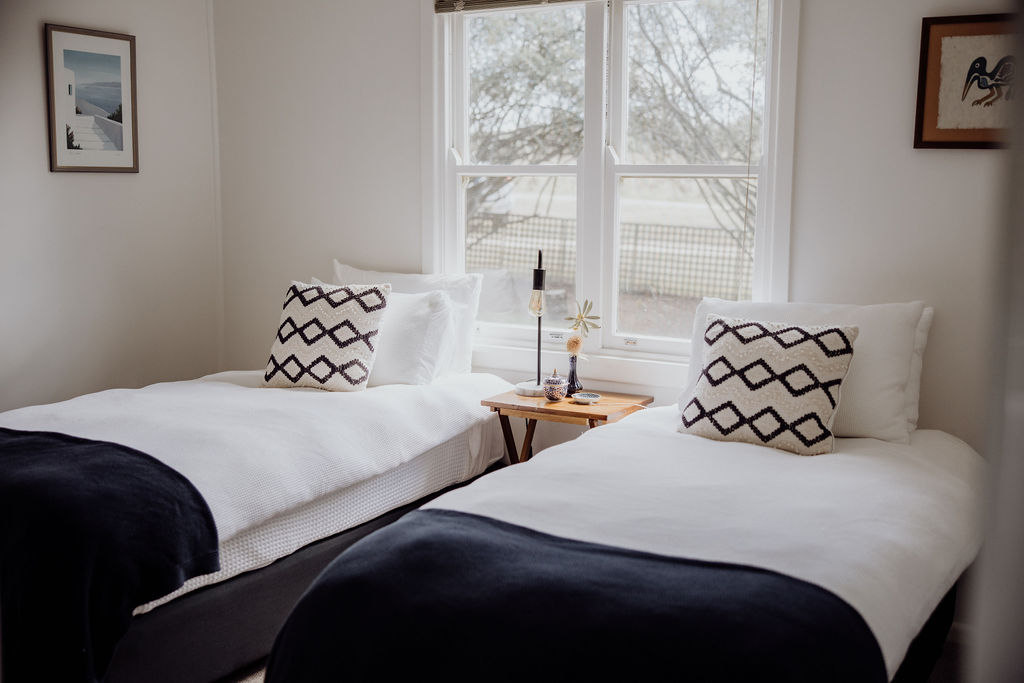 Light-filled twin bedroom with soft white linen and modern, cosy touches—ideal for friends, siblings, or guests travelling solo. Stylish yet simple design offers comfort and flexibility for all types of stays.