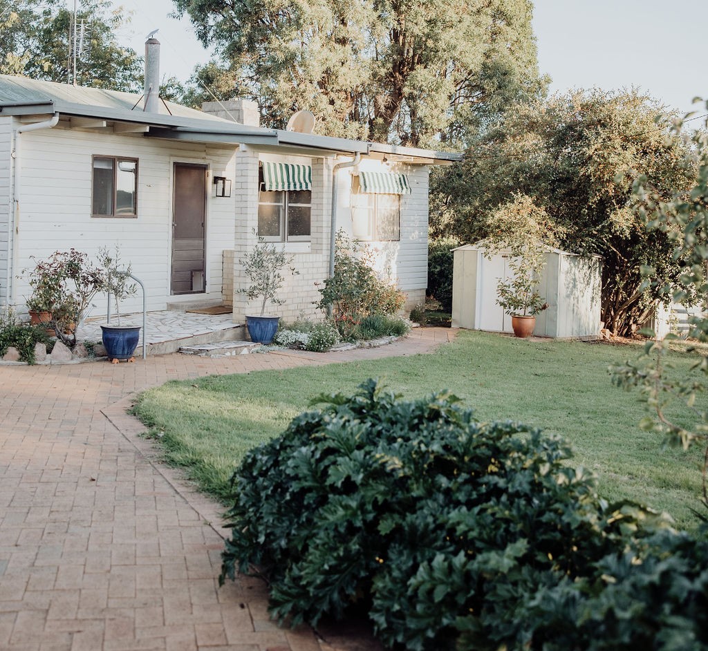 Paving extends from the front gate t the front door making access easy. One step with a rail leads to the porch and two steps take you into the house.